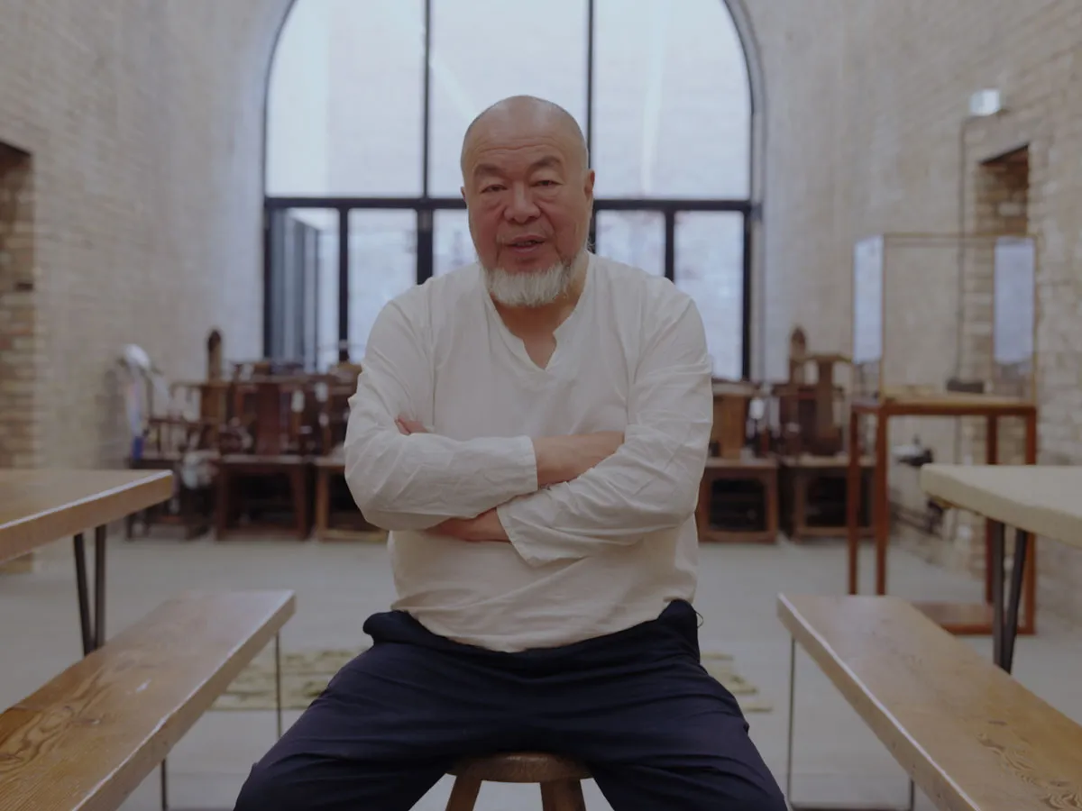 Ai Weiwei sits on a stool in his studio.