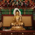 A golden statue of a lady with her legs crossed.