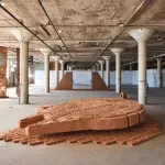 View of sculptures on view in an industrial space.