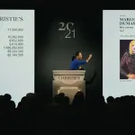 An auctioneer at a podium beside an image of a painting showing a woman with one hand bent at her waist.