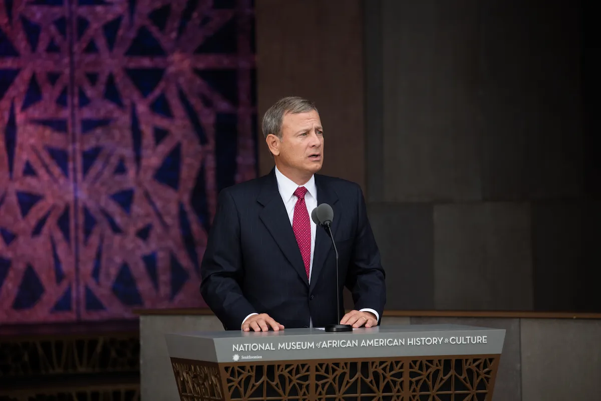 A man in a suit at a podium.