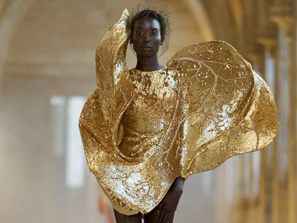 A tall slender woman in a fantastical golden dress.