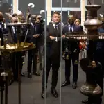 A man staring into a vitrine with ceremonial objects.