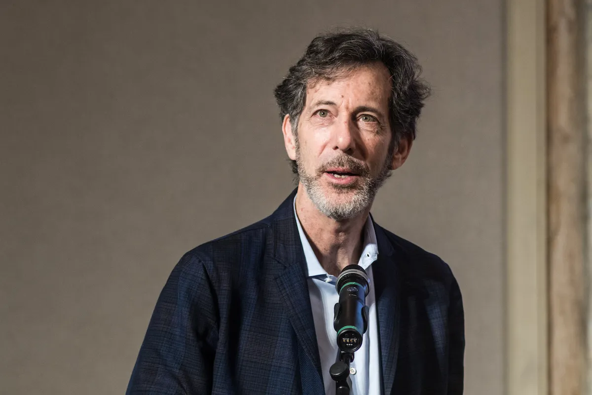A man in a suit speaking into a microphone.