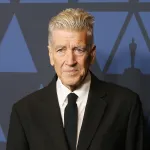 A man in a suit on a red carpet.
