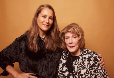 Two women in dresses with their arms around each other