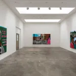 View of an art gallery exhibition with three paintings on three different walls.