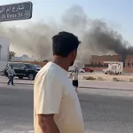 This frame grab taken from an AFPTV footage shows a man looking at smoke billowing after explosions in Qatar