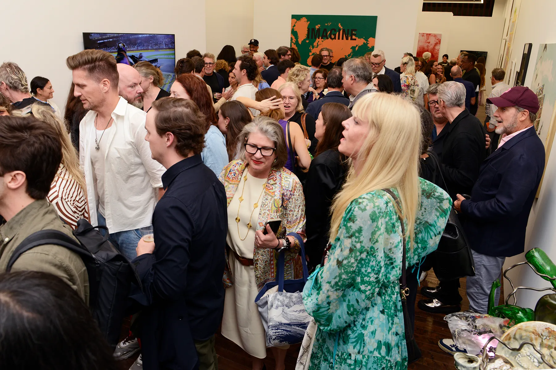 A lot of people crammed into an art gallery.