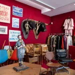 A view of a museum with red velvet walls and various objects owned by Sophie Calle.