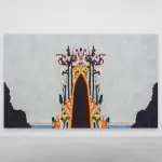 A colorful figure seems to emerge out of the ground in front of a grey sky.
