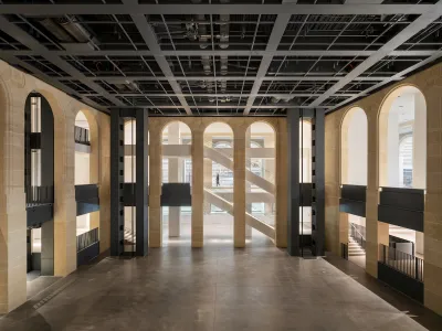 An empty, cavernous room with staircases running down its sides.