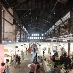 A giant warehouse in which an art fair is going on.