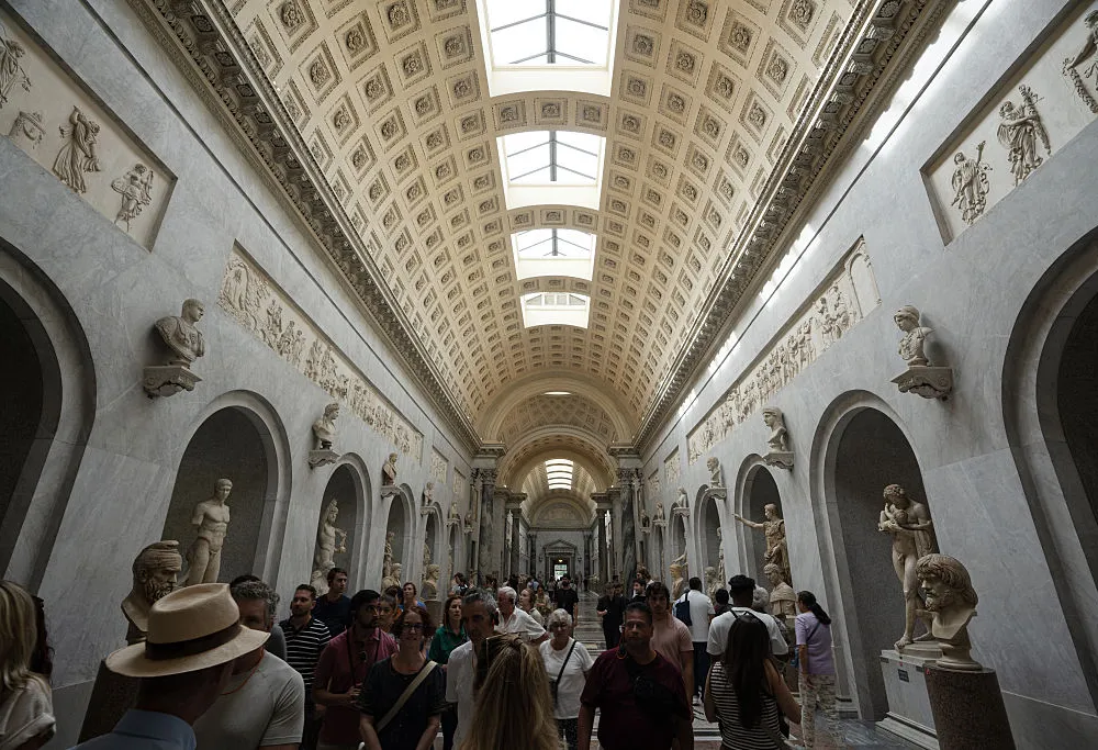 Crowds of people passing through a museum hall.