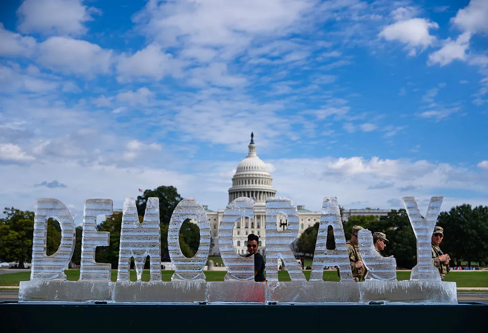 Members of the National Guard walk by a 3,000-pound ice sculpture by artists Nora Ligorano and Marshall Reese on the National Mall in Washington, DC, 2025.