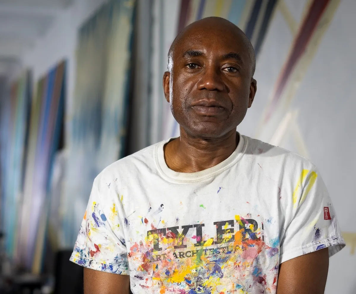 A man in a paint-splattered T-shirt