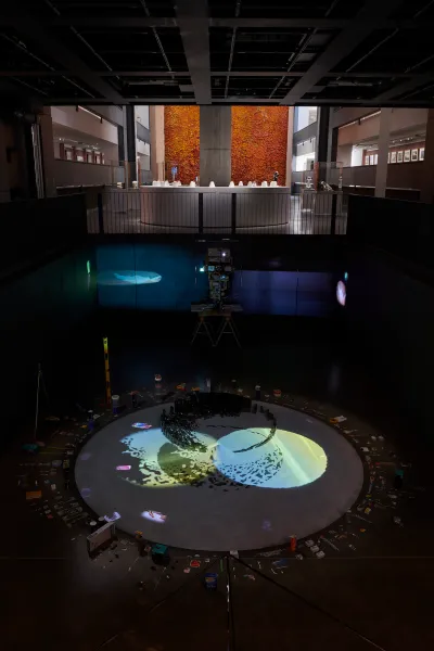 A darkened room with an abstract light projection on a circular floor.