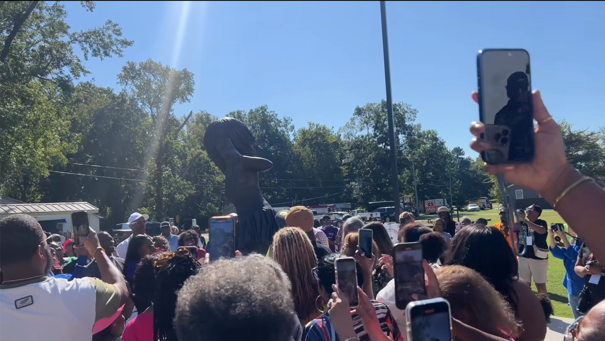 A group of people taking pictures of a statue.