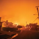 LOS ANGELES, CALIFORNIA - JANUARY 8: View of Radcliffe avenue as the Palisades Fire burns in during a powerful windstorm on January 8, 2025 in the Pacific Palisades neighborhood of Los Angeles, California. The fast-moving wildfire is threatening homes in the coastal neighborhood amid intense Santa Ana Winds and dry conditions in Southern California. (Photo by Apu Gomes/Getty Images)