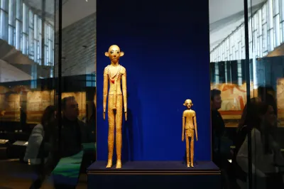 Two gold-plated statues, one figure is larger than the other.