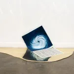An installation in which a paper handout with an aerial view of a hurricane is embedded in a pool of hardened gold.