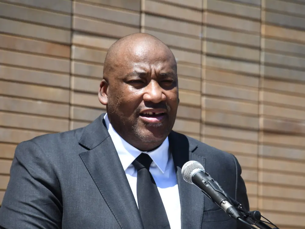 Portrait of Gayton McKenzie speaking into a microphone.