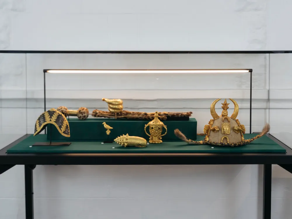 Golden artifacts in a glass display case.