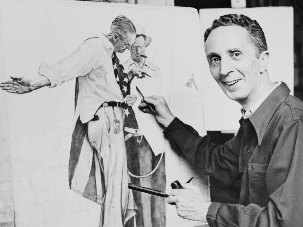 A man painting an image of a man draped in American flag.