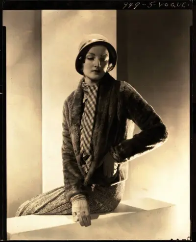 A woman in a dress and scarf seated on a balcony.