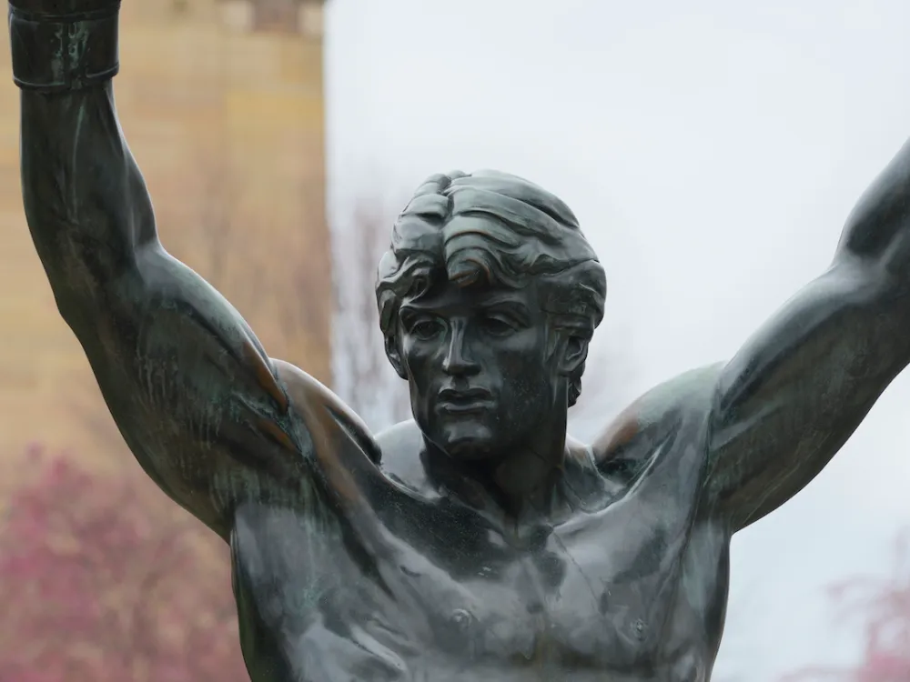 A statue of a boxer with his hands raised.