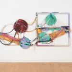 A colorful abstract composition of multiple painted circles and rectangles hangs on the wall, crossed by ropes.