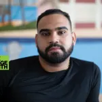 Portrait of Bony Ramirez, which a painting out of focus in the background.