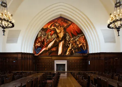 A mural of a nude figure surrounded by flames in an apse-like structure.