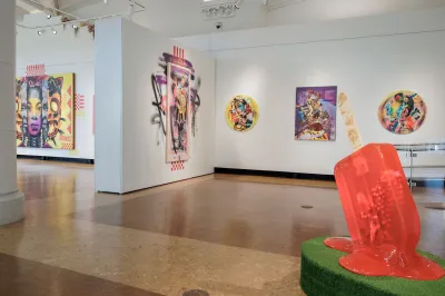 View of an art exhibition with paintings and sculpture on view.