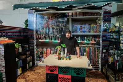 Portrait of Victor Quiñonez in an art installation resembling a bodega.