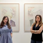 Portrait of Beatriz Cifuentes and Faiza Butt in front of two paintings.