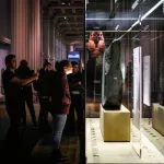 A group of people looking at a stone in a vitrine.