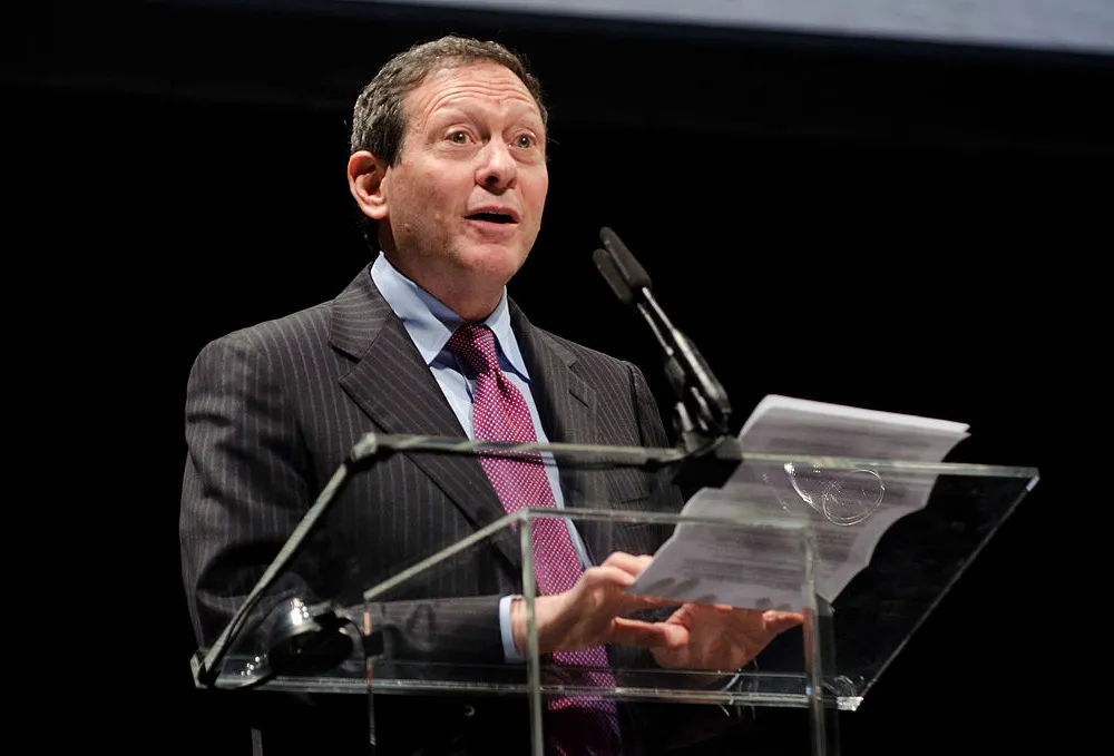 A man at a podium reading from a sheet of paper.