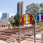 Some steps and stained glass installations against a city scape.