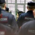 A woman is led away by police officers.