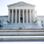 A white marble building with a pillars.