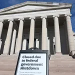 A classically styled museum facade with a clapboard sign reading 
