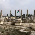 A man drives his tractor past ruins at the archaeological site of Sebastia, west of the occupied West Bank city of Nablus on November 30, 2025. Israeli cultural watchdog Emek Shaveh denounced on November 24, a decision to expropriate nearly 500 acres (1,800 dunams) of private Palestinian land in the occupied West Bank near the ancient archaeological site of Sebastia. Sebastia is an archaeological site dating back to the Iron Age, which Israel began taking interest in in 2023, first with a plan for the site itself, and then the seizure of the top of the mound that constitutes the site, Emek Shaveh said. (Photo by JAAFAR ASHTIYEH / AFP via Getty Images)