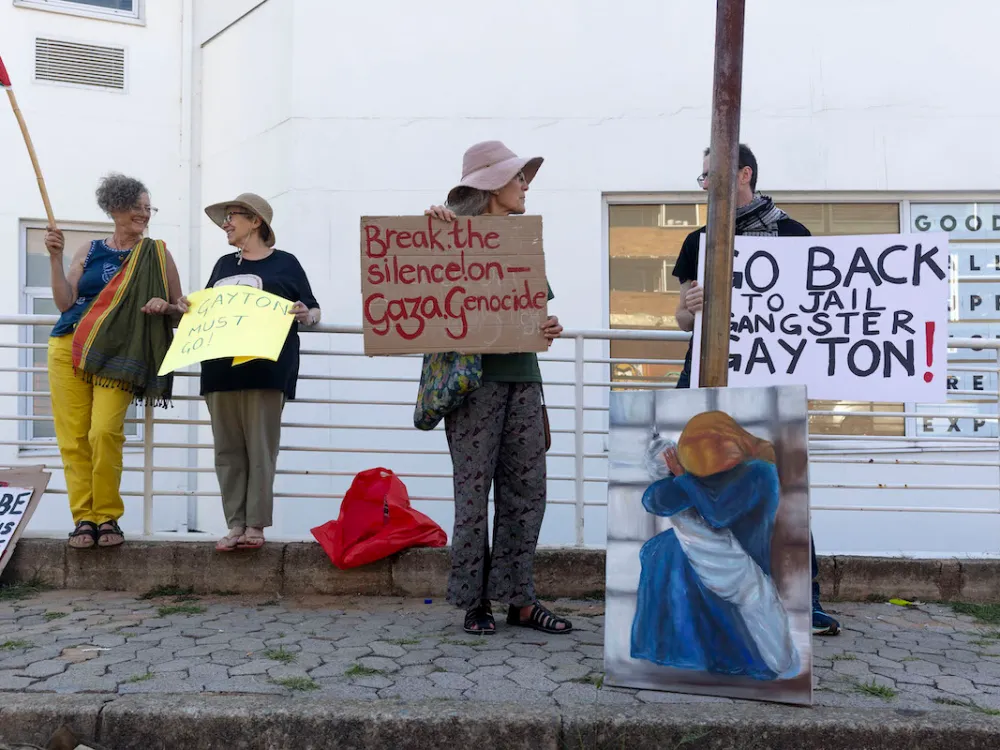 Activists holding signs and flying a Palestinian flag.