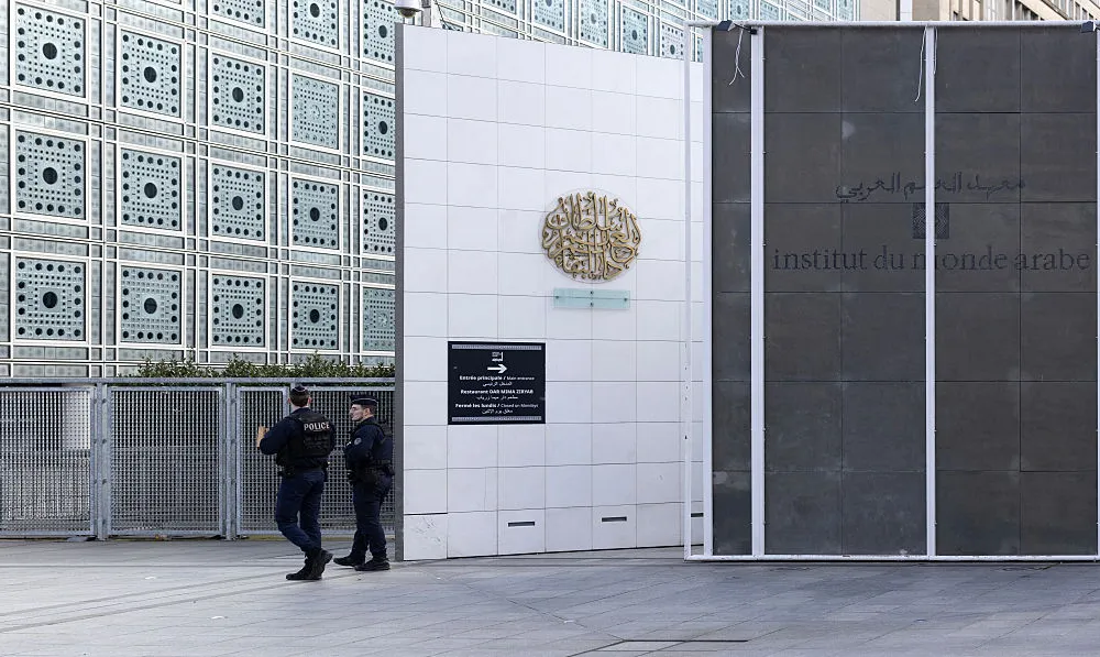 TOPSHOT - French police officers patrol in front of the Institut du Monde Arabe (IMA - Arab World Institute) during a search as part of investigations entrusted to the National Anti-Fraud Office (ONAF) on the Epstein case linked to its president Jack Lang, at the Institut du Monde Arabe in Paris on February 16, 2026. Former French Culture Minister Jack Lang has offered his resignation from the Arab World Institute (Institut du Monde Arabe de Paris - IMA), which he has chaired since 2013, over Epstein links, according to a letter seen by AFP on February 7, 2026. (Photo by Charlotte SIEMON / AFP via Getty Images)