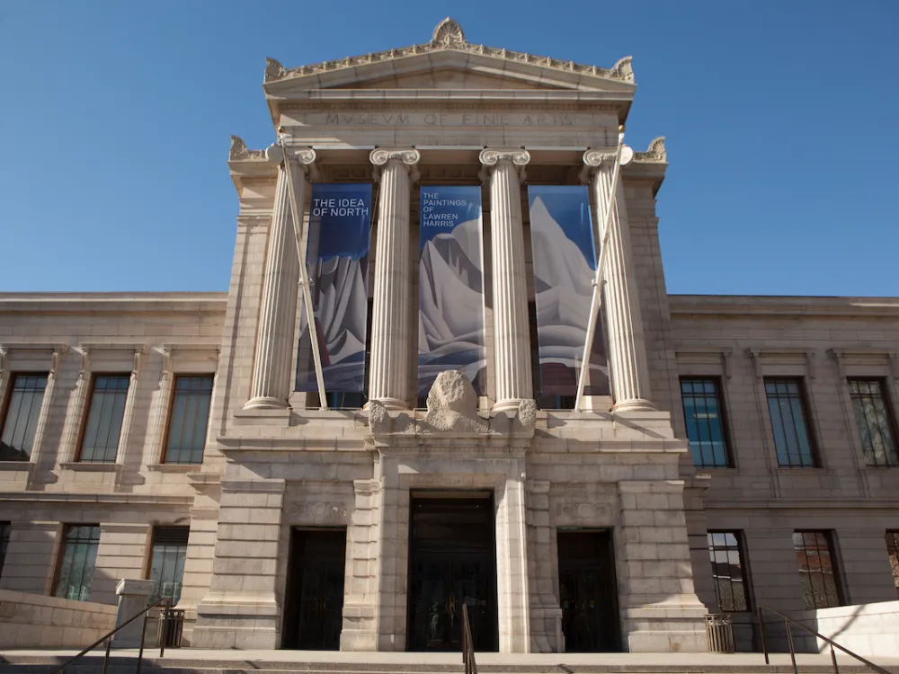 A columned museum facade with a banner displaying a painting of a mountain.