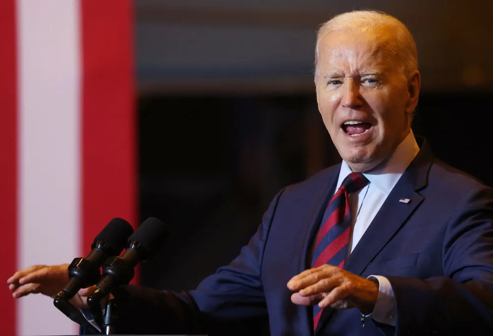 A man in a suit speaking into a microphone.