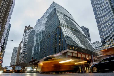 People walk and cars drive outside the glass-fronted James R. Thompson Center in Chicago