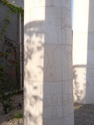 A column etched with the profiles of people.