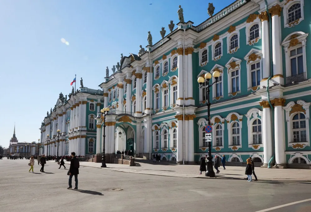 An ornate light blue museum building with white columns, white framed windows, and ornate gold moulding.